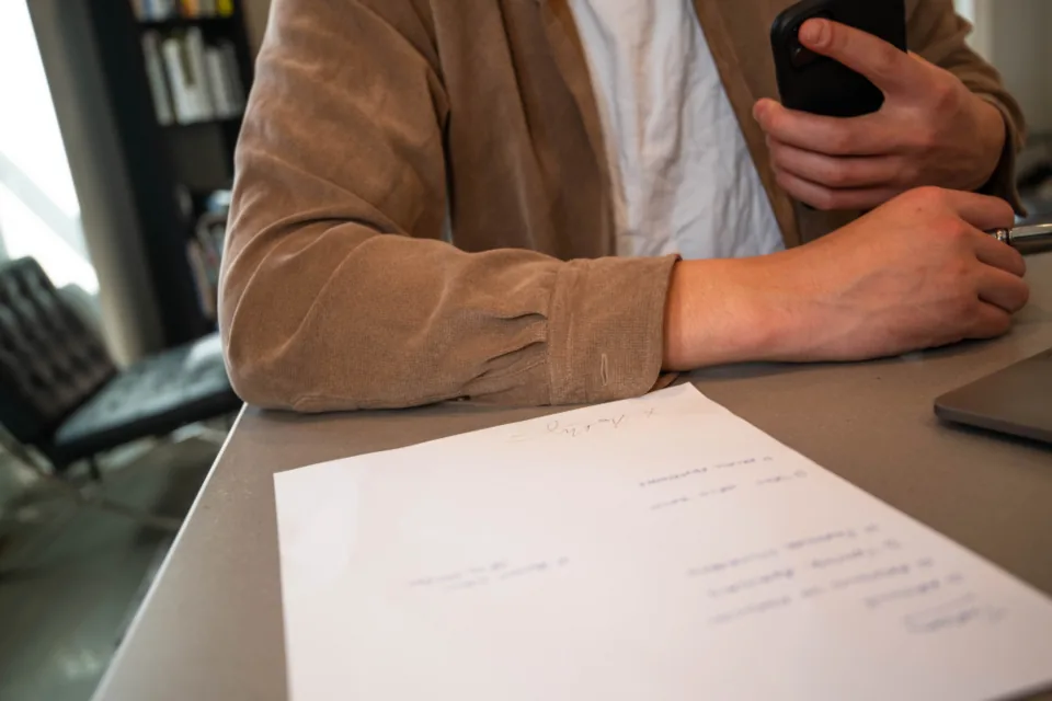 Manos organizando documentos personales sobre un escritorio